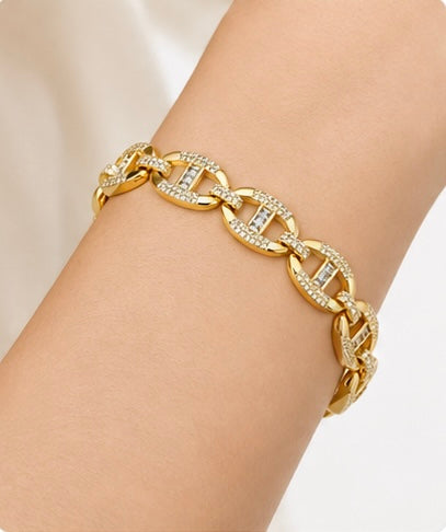 Joyjocey Gold-Plated Crystal Link Bracelet worn on the wrist, showing its polished oval links and crystal accents.