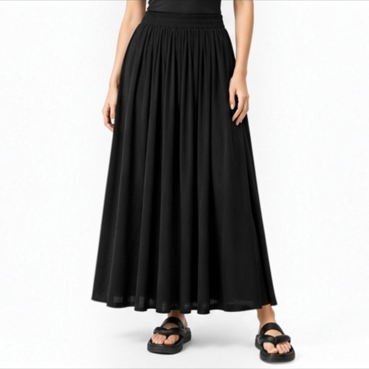 Model wearing the black Joyjocey High-Waist Pleated A-Line Skirt with a flowy maxi-length silhouette, front view.