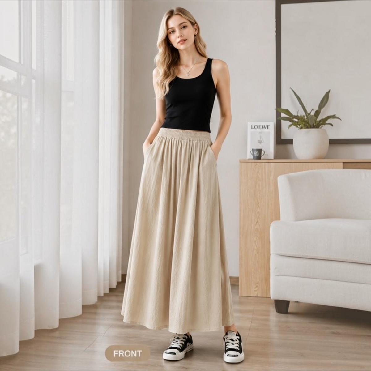 Model wearing the khaki Joyjocey High-Waist Pleated A-Line Skirt with a black tank top and sneakers, front view.