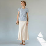 Model styling the light blue Joyjocey Classic Side-Knot Cotton T-Shirt with a cream maxi skirt and shoulder bag.