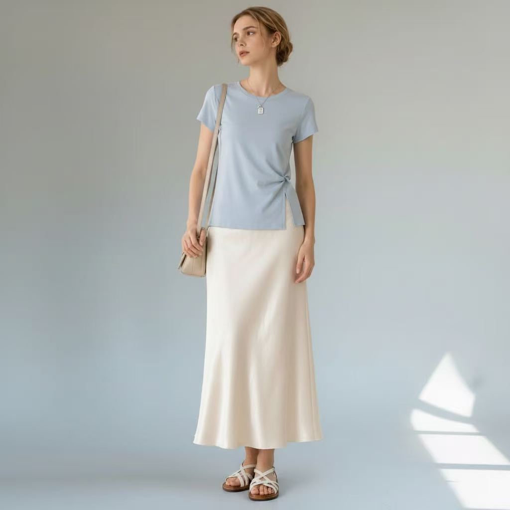 Model styling the light blue Joyjocey Classic Side-Knot Cotton T-Shirt with a cream maxi skirt and shoulder bag.