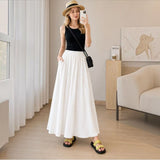 Model styling the creamy white Joyjocey High-Waist Pleated A-Line Skirt with a black tank top, sun hat and sandals.