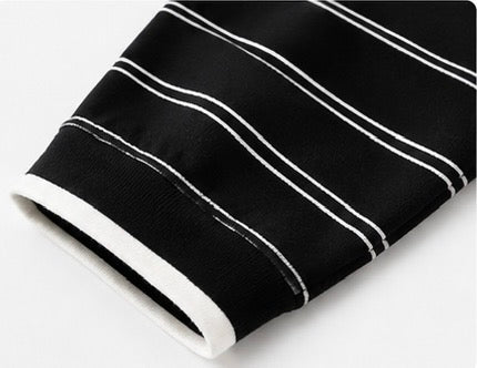 White-trimmed cuff and horizontal stripe detail on the black Joyjocey Relaxed Striped Long-Sleeve Top.