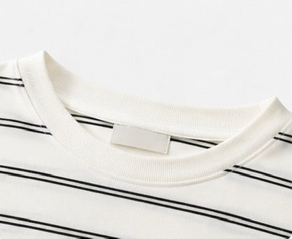Round neckline and thin black stripe detail on the white Joyjocey Relaxed Striped Long-Sleeve Top.