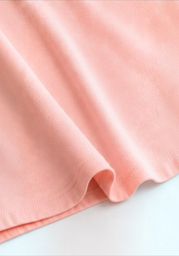 Close-up of the soft pink cotton fabric and finished hem on the Joyjocey Side-Tie Cotton Top.