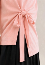 Adjustable pink waist tie and asymmetrical side slit detail on the Joyjocey Side-Tie Cotton Top.