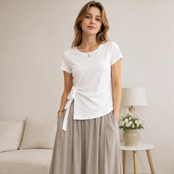 Model wearing the Joyjocey Side-Tie Cotton Top in white with an asymmetrical hem and adjustable waist tie, front view.